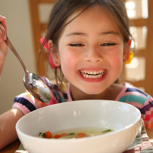 child eating soup