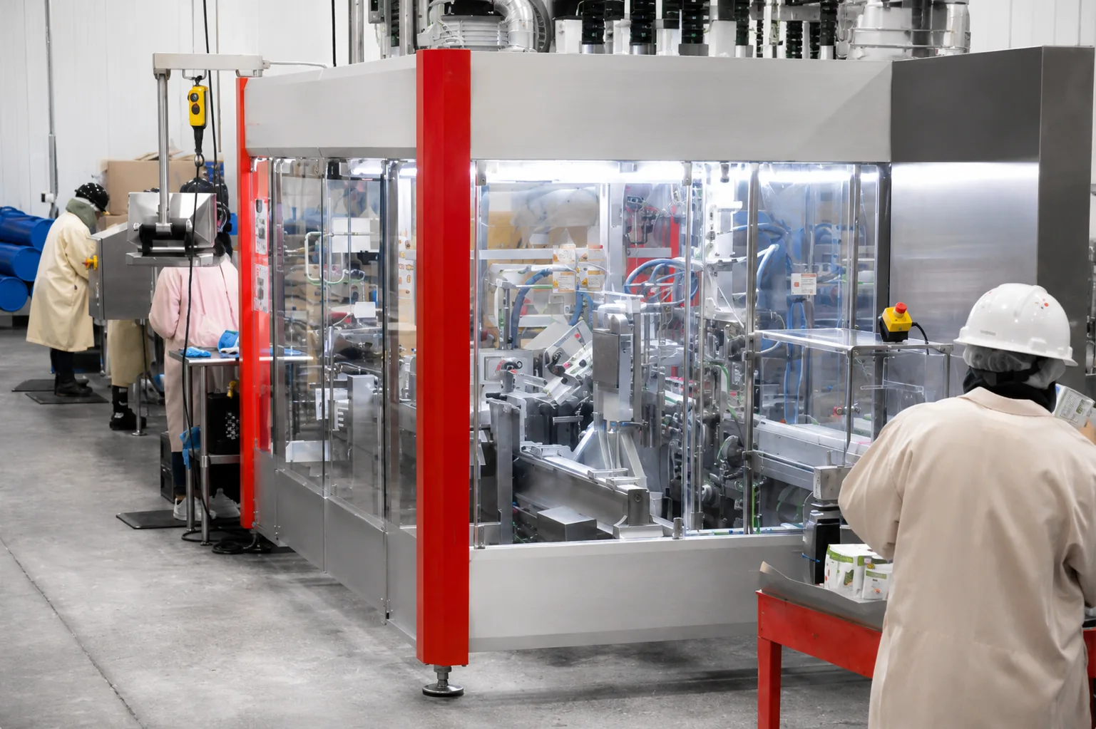 Workers operating automated packaging equipment inside an APC food production facility